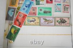 Collection mondiale de plus de 1 250 timbres neufs et oblitérés, conservés dans un album Harris